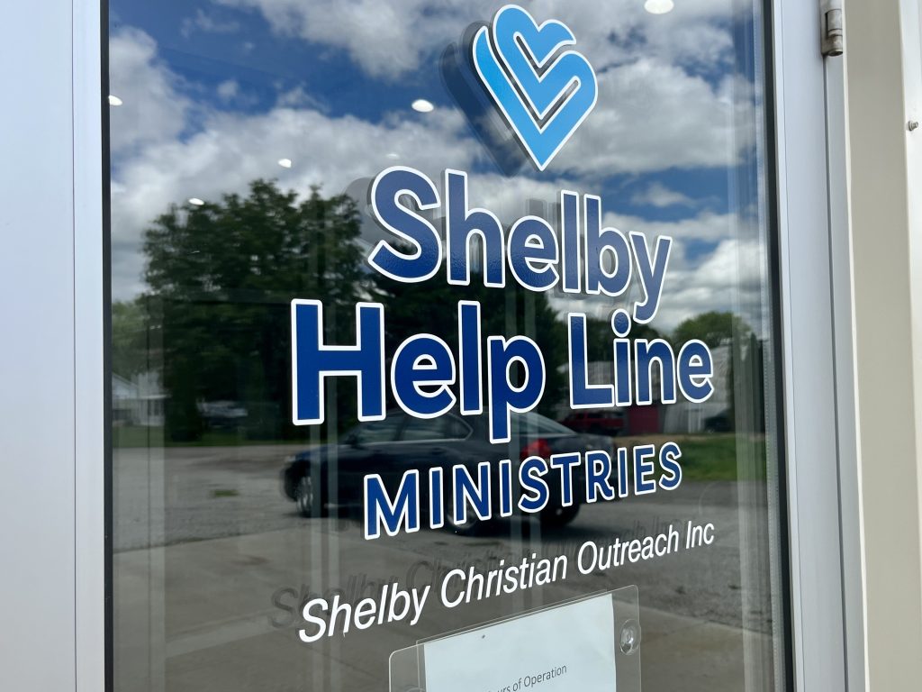 Glass door with Shelby Help Line Ministries sticker displayed