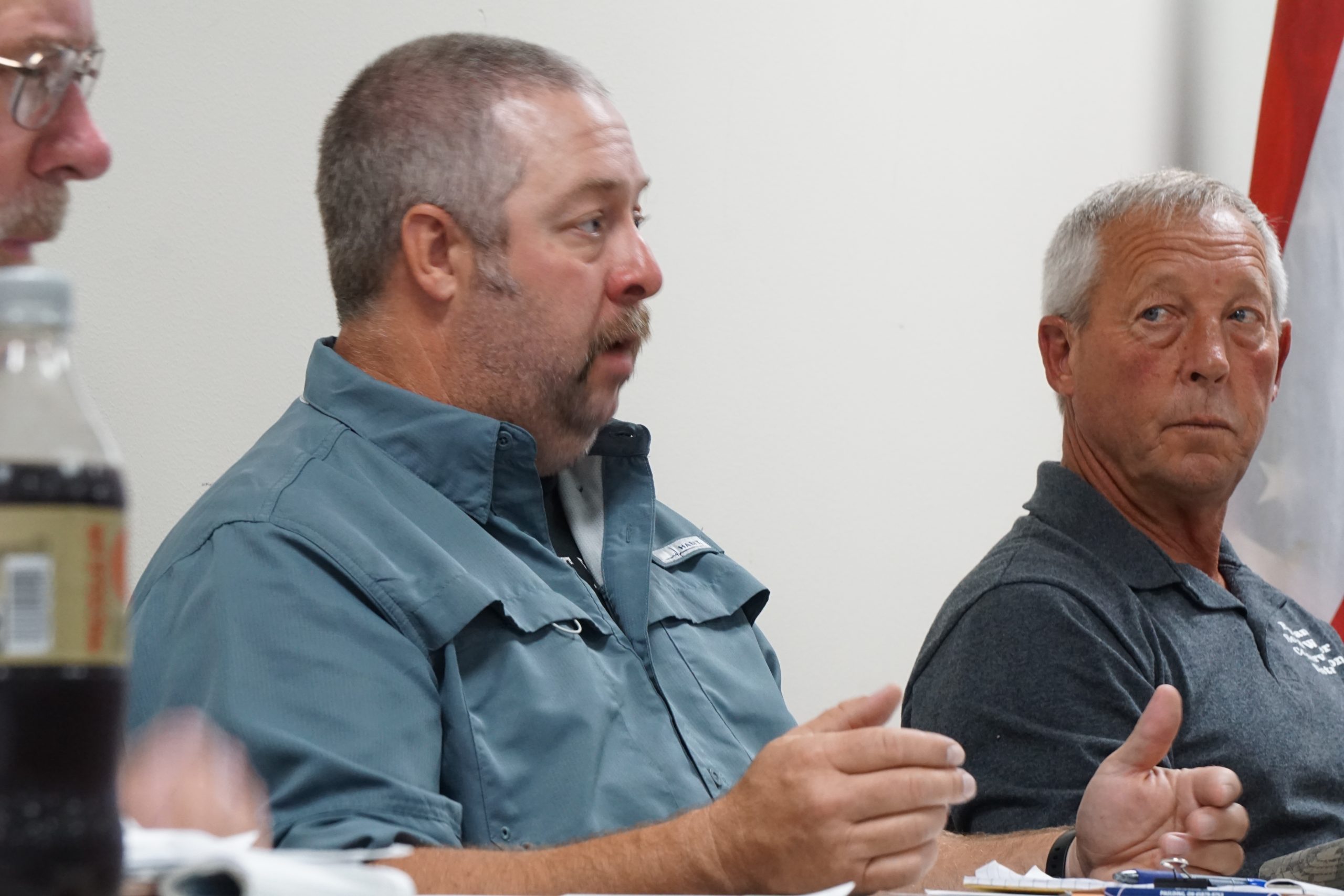 Man with green shirt speaking.