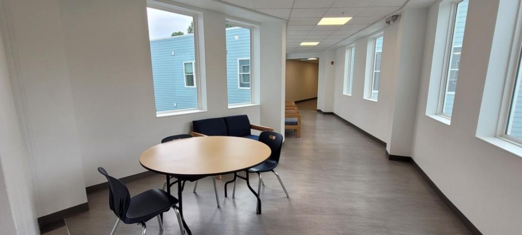 hallway with a set of table and chairs and lots of windows