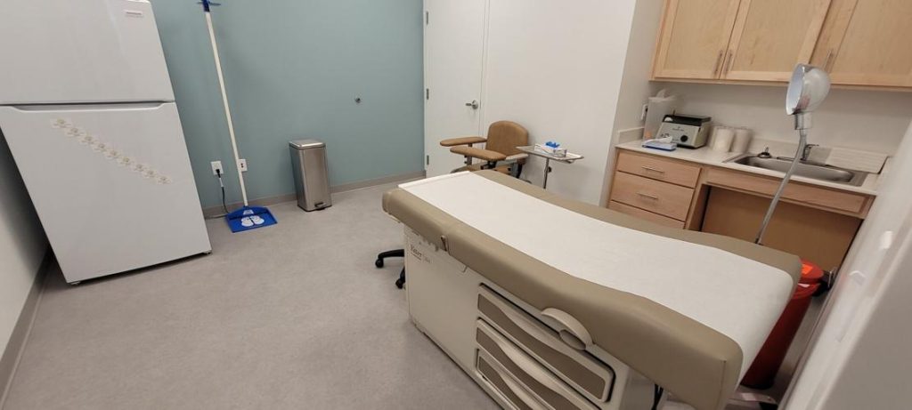 room in a clinic with examination table and sink
