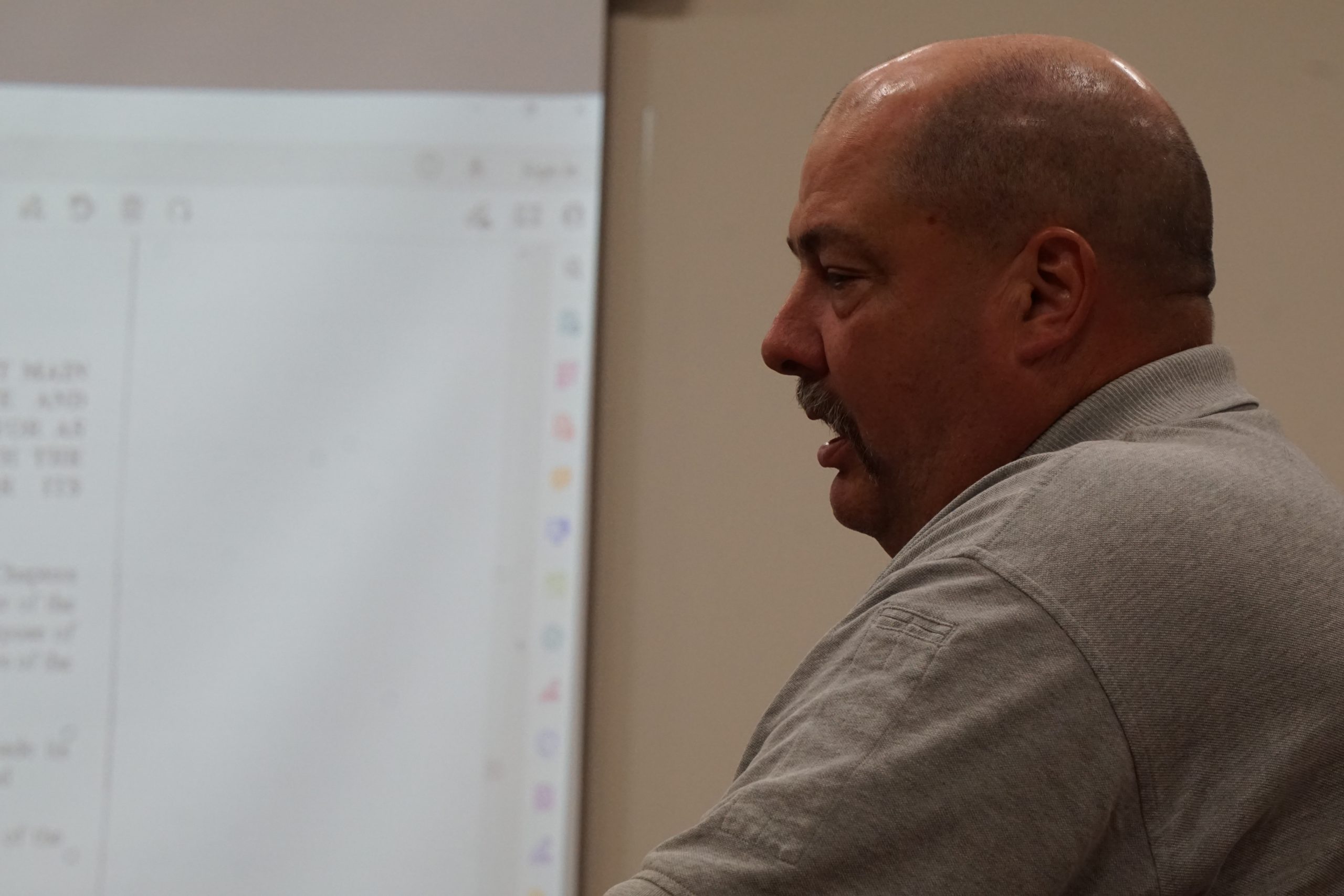 Man in gray polo discussing damaged property.