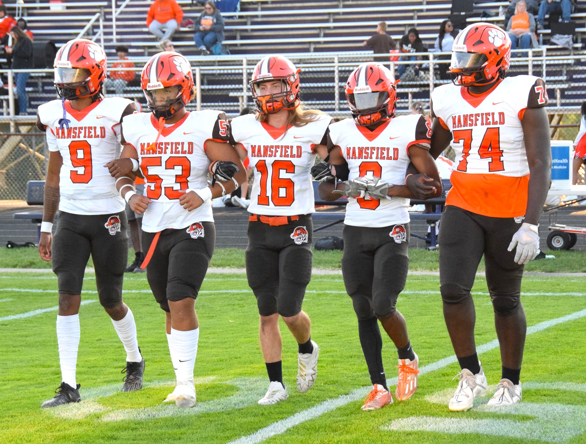Five football players in white jerseys at midfield