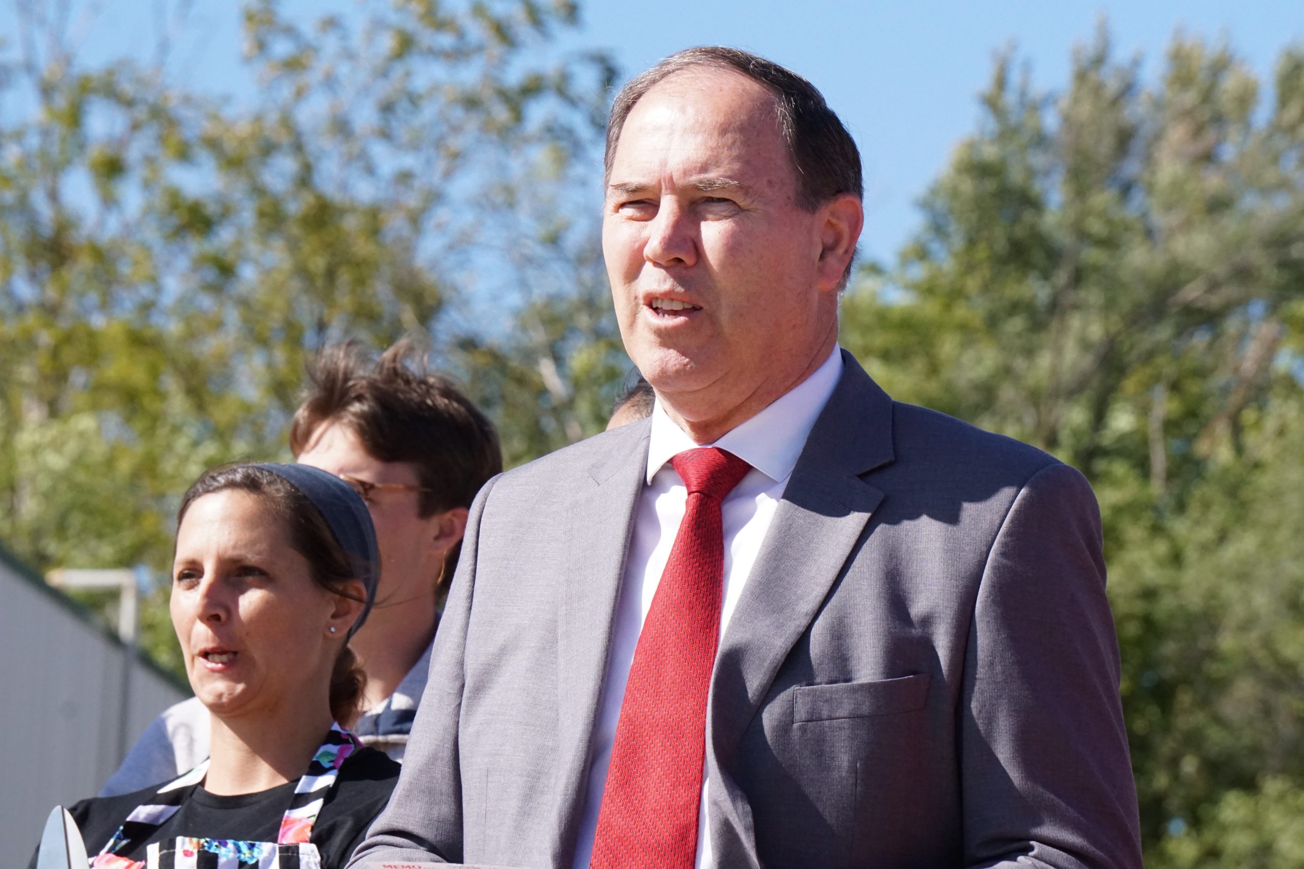 Man in gray suit with red tie.