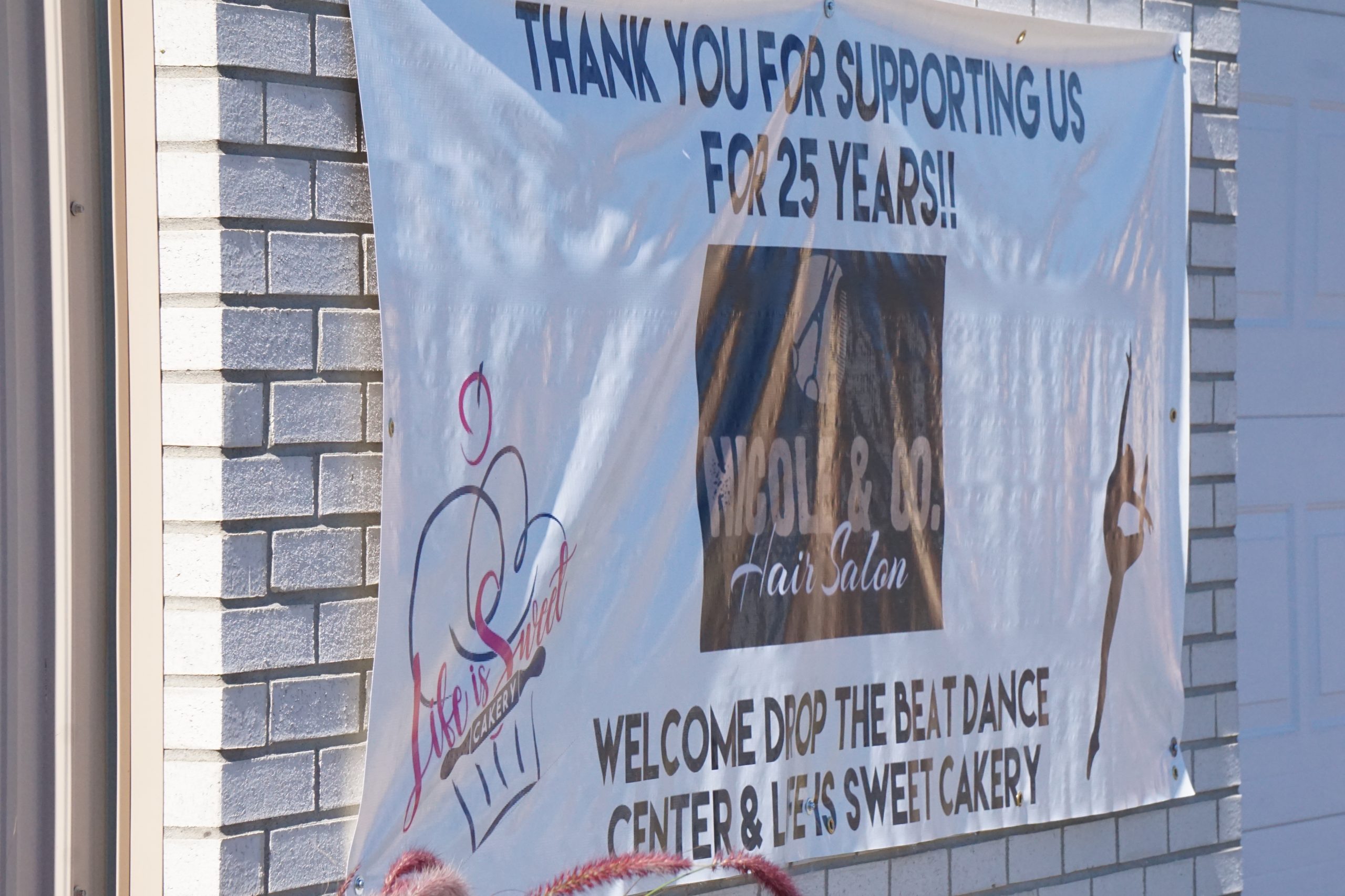 Decorative banner hanging on brick wall.