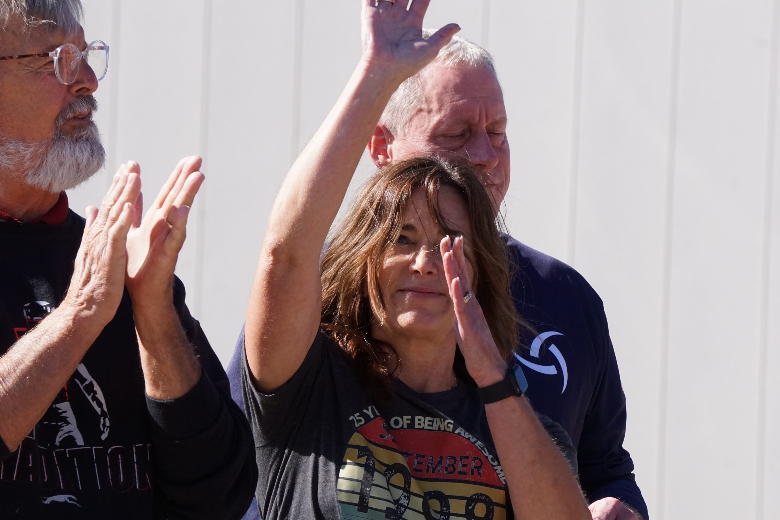 Women waving to crowd of people.