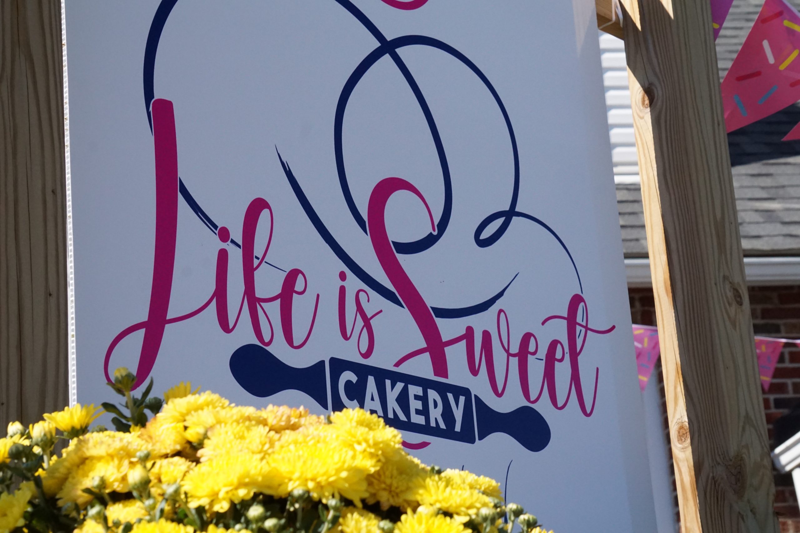 Business sign that reads "Life is Sweet Cakery".