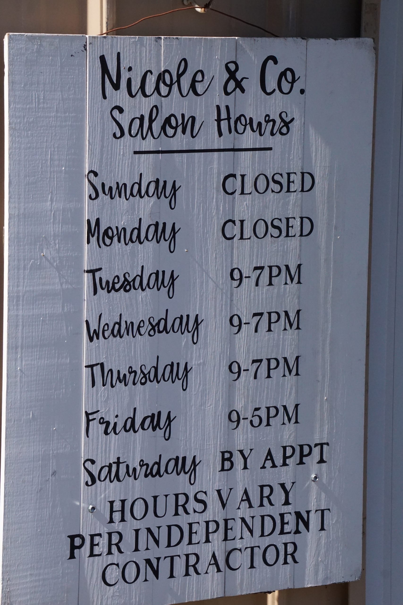 Business sign with store hours.