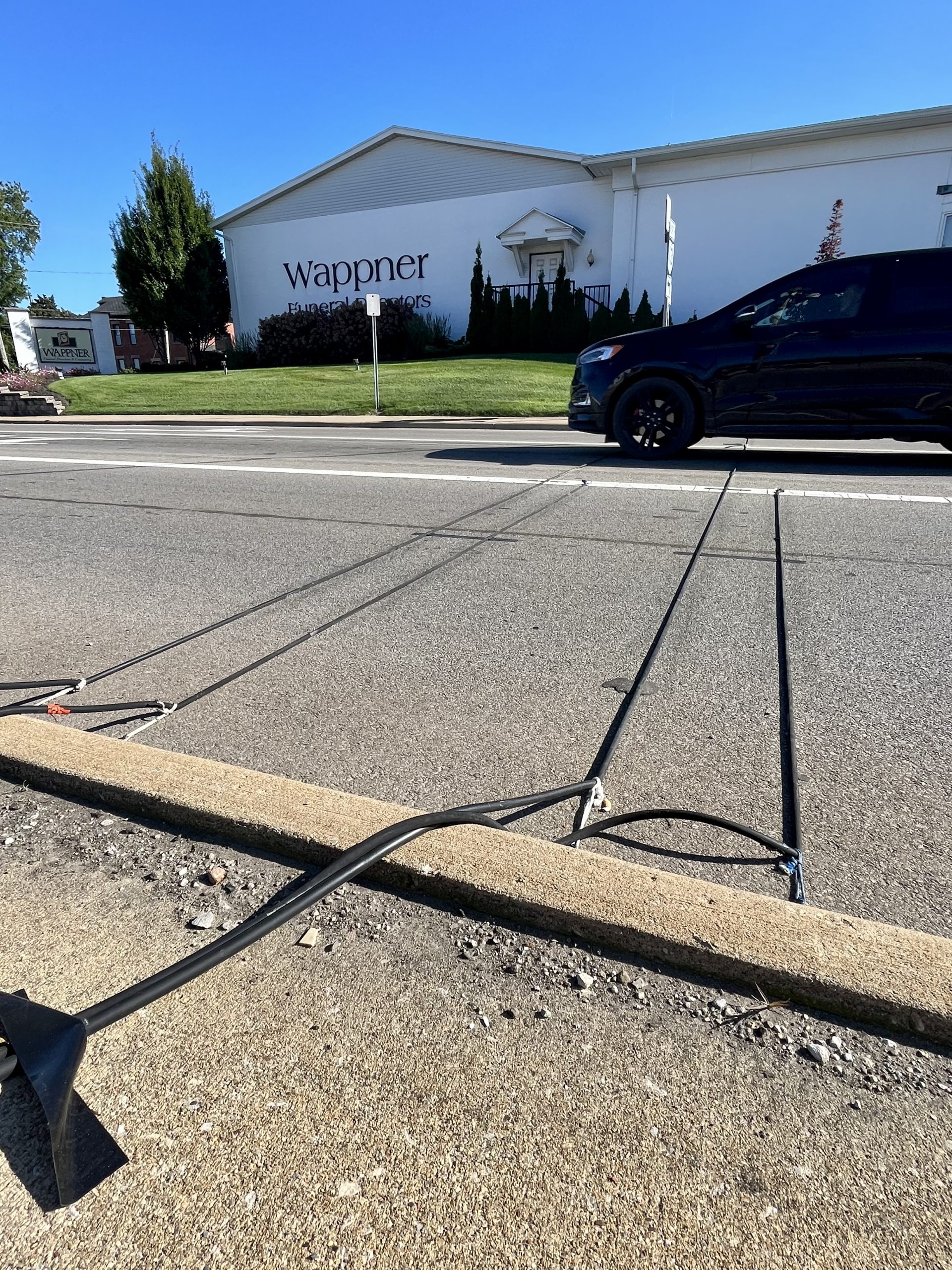 Car driving over traffic study equipment