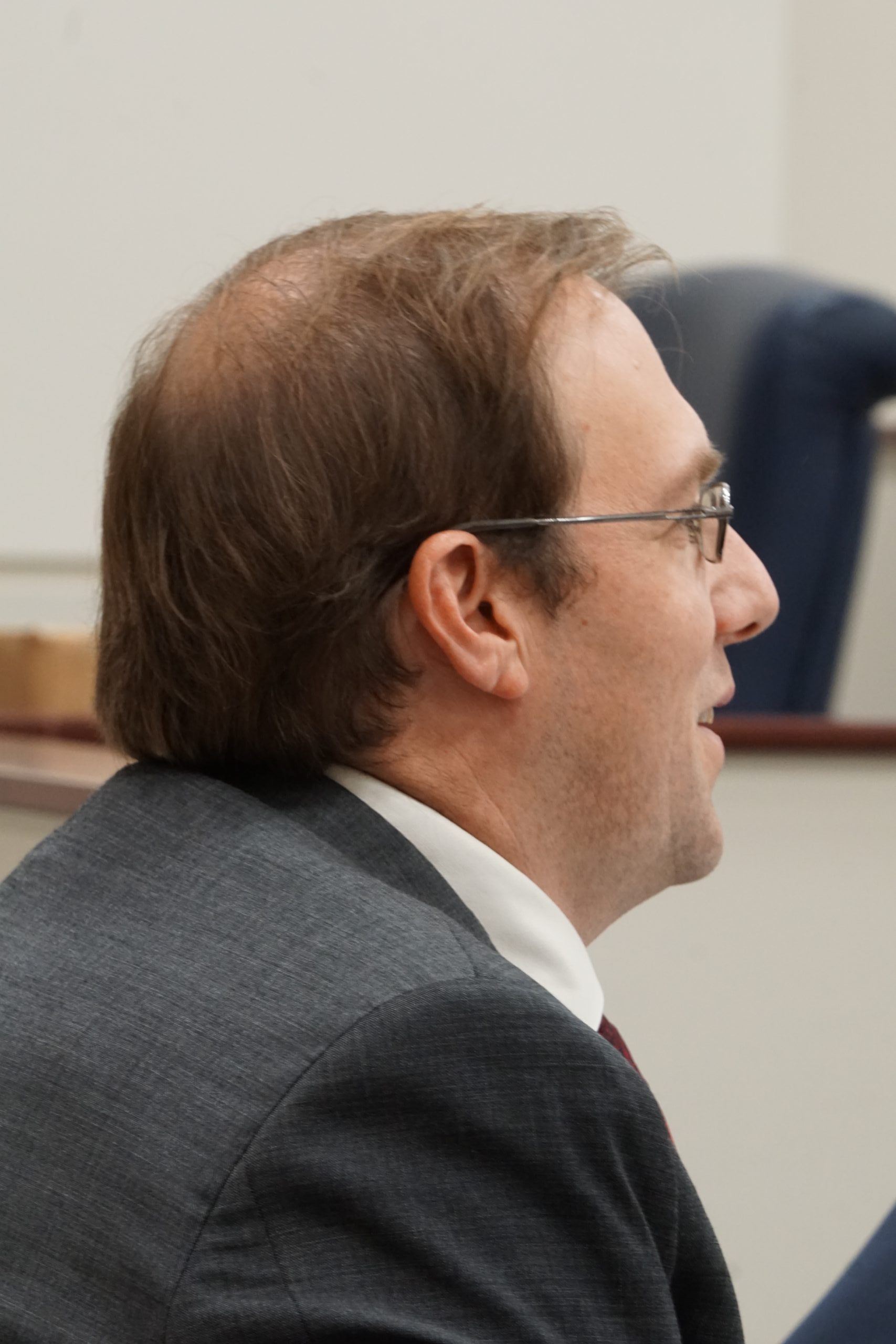 Man in black suit and glasses.