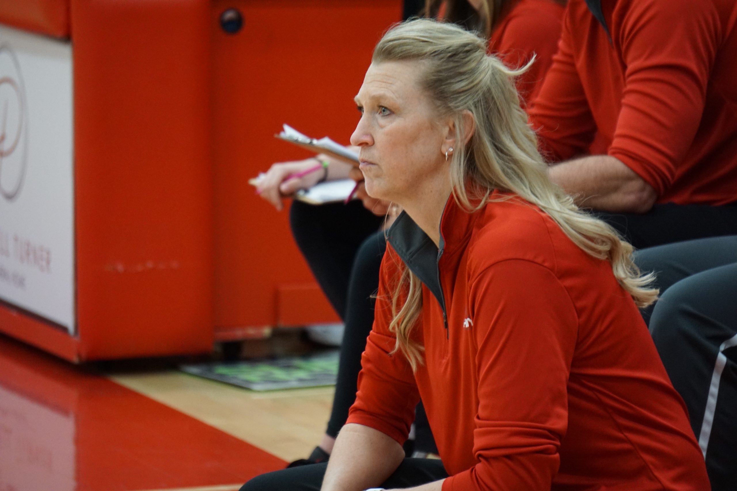 Basketball coach kneeling on court