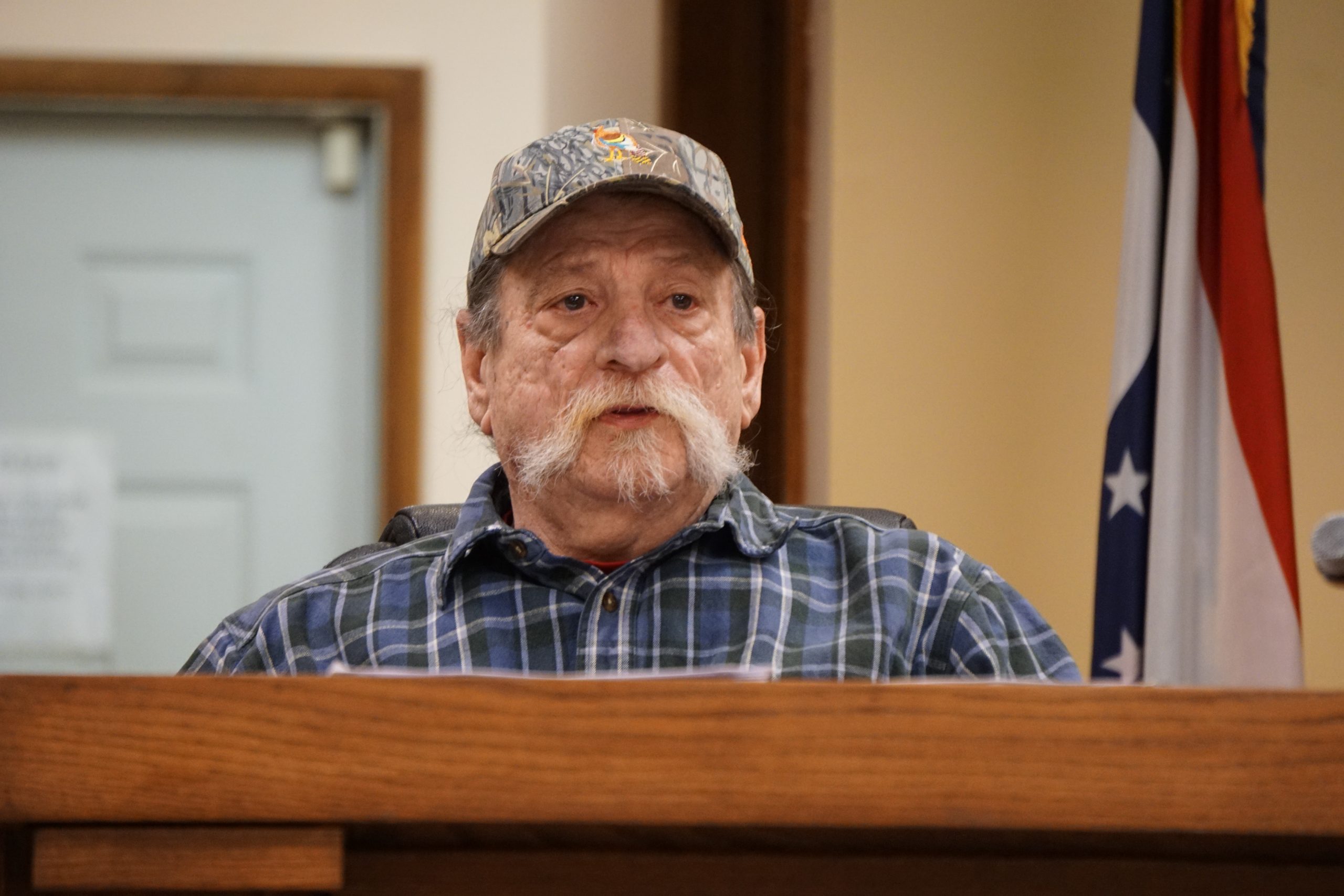 Man in dress shirt and hat.