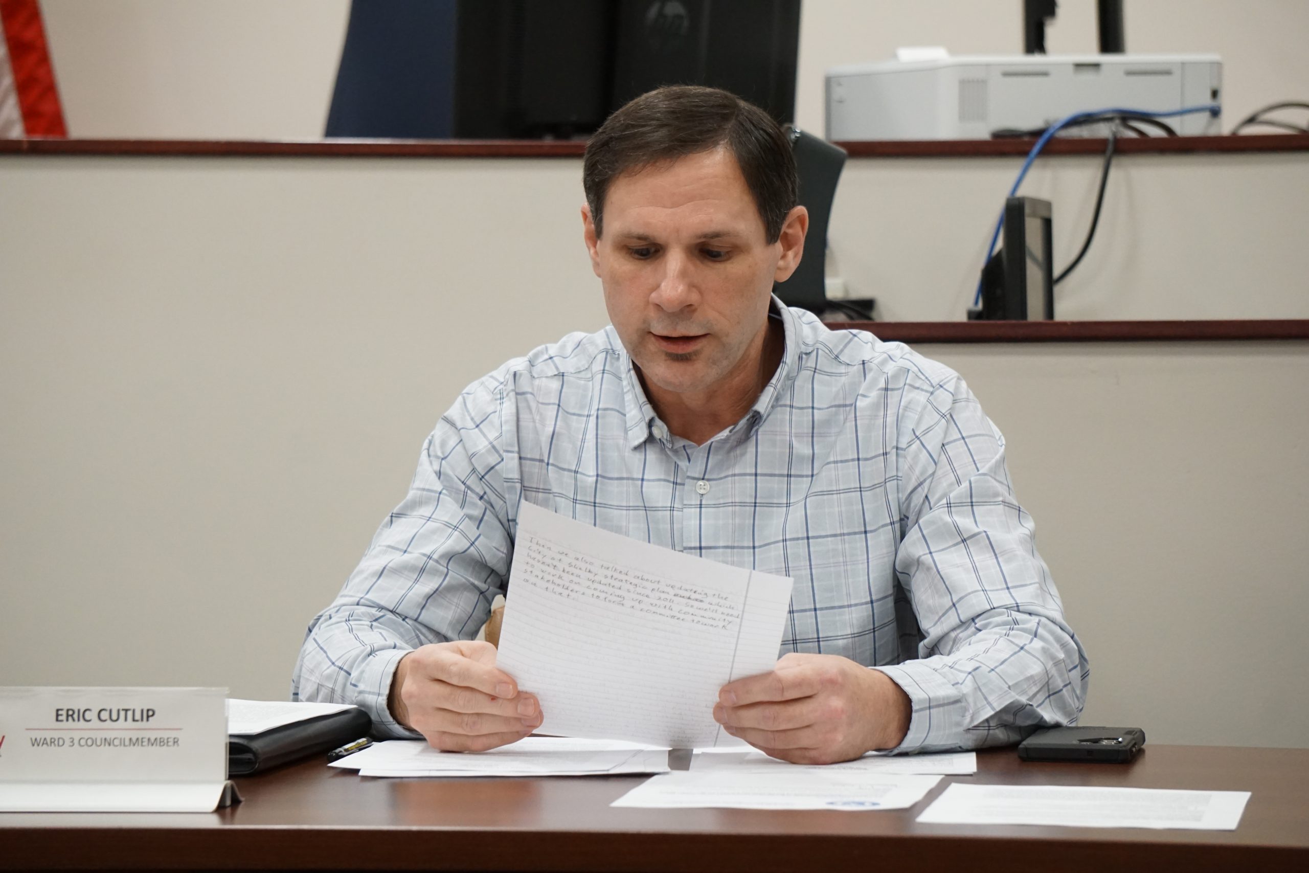 Man in dress shirt reading a paper