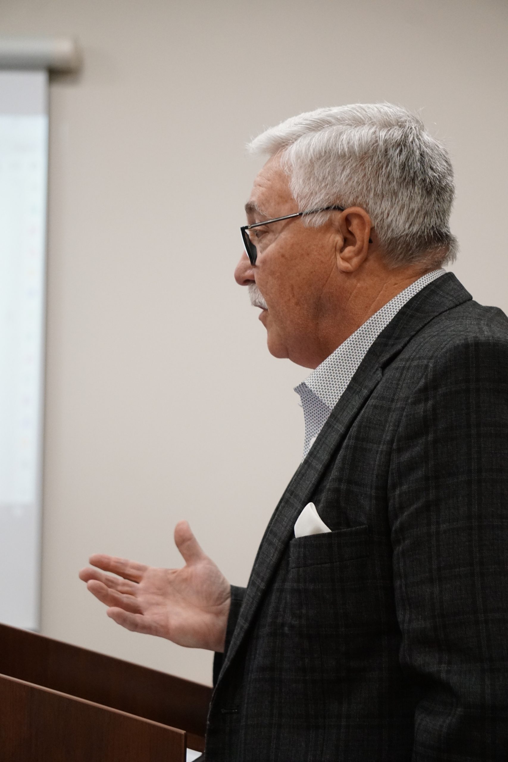 Man in suit speaks at podium