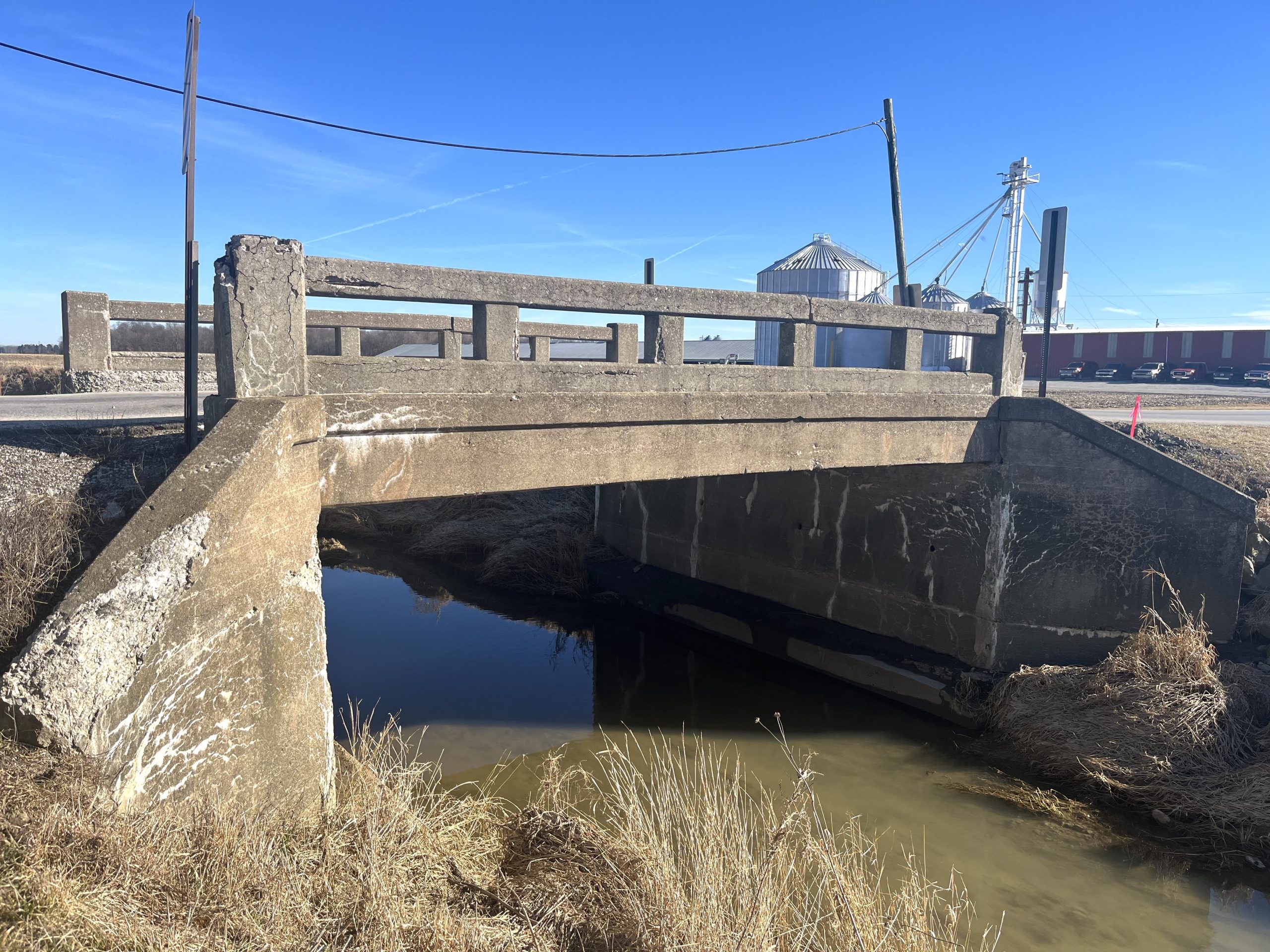 Concrete slab bridge over small stream of water.
