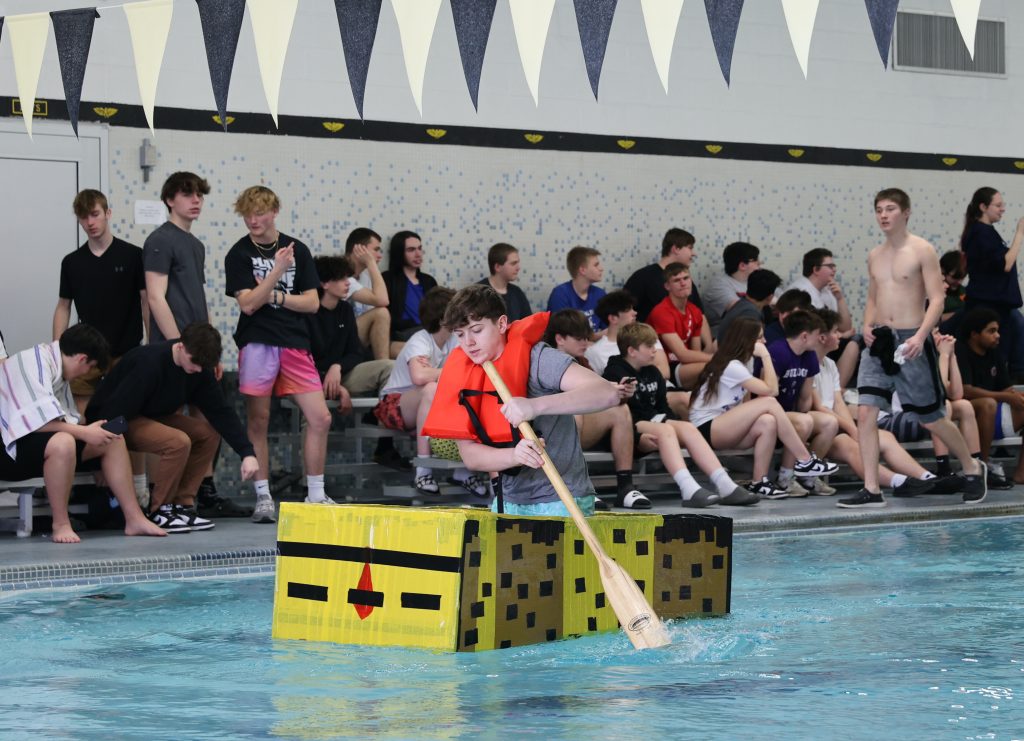 teenage girl races in Mike Cauley cardboard boat regatta at Colonel Crawford High School