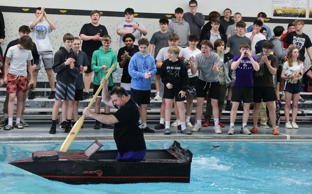 principal Jason Knight races in Mike Cauley cardboard boat regatta at Colonel Crawford High School