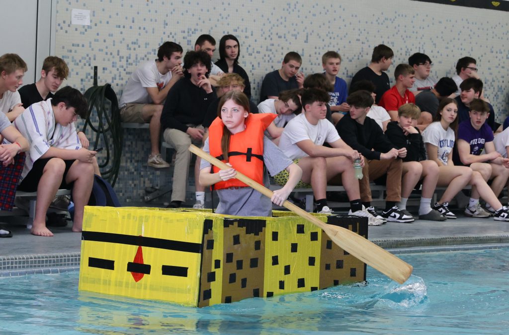 teenage girl races in Mike Cauley cardboard boat regatta at Colonel Crawford High School