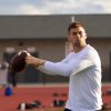 a football player throws a pass during a drill